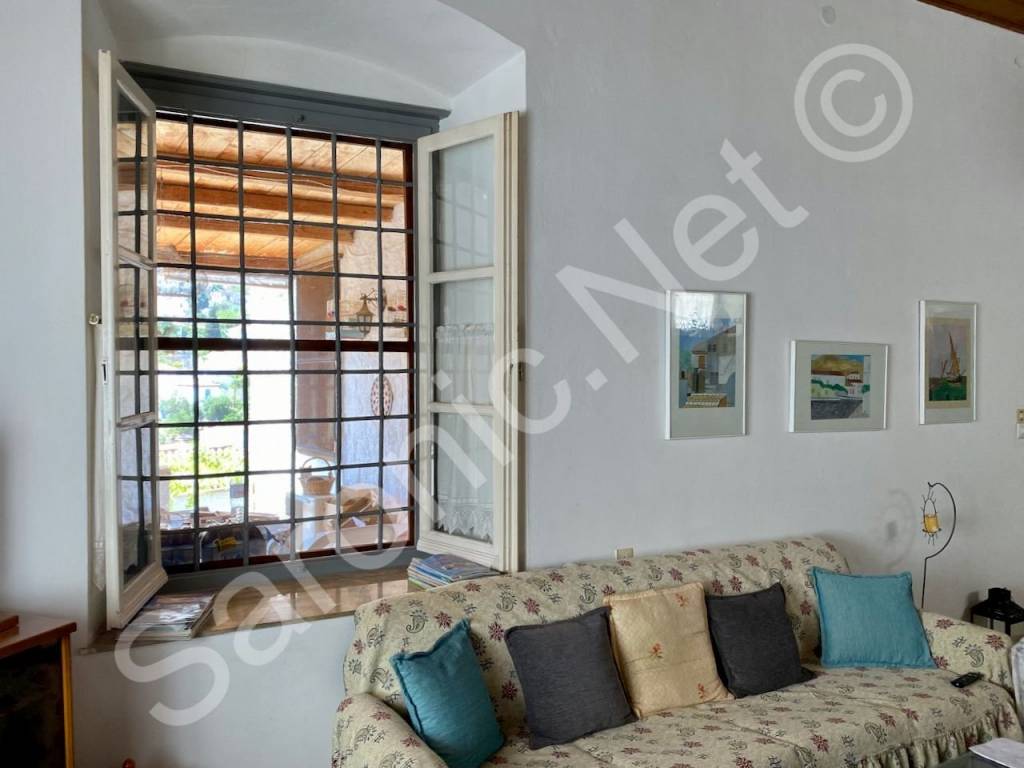 Living room window looks out to loggia and inland views