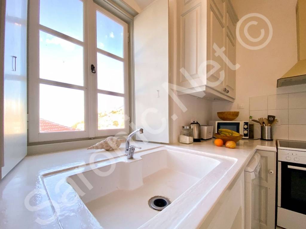 Large ceramic sink in kitchen, with good sized window above.