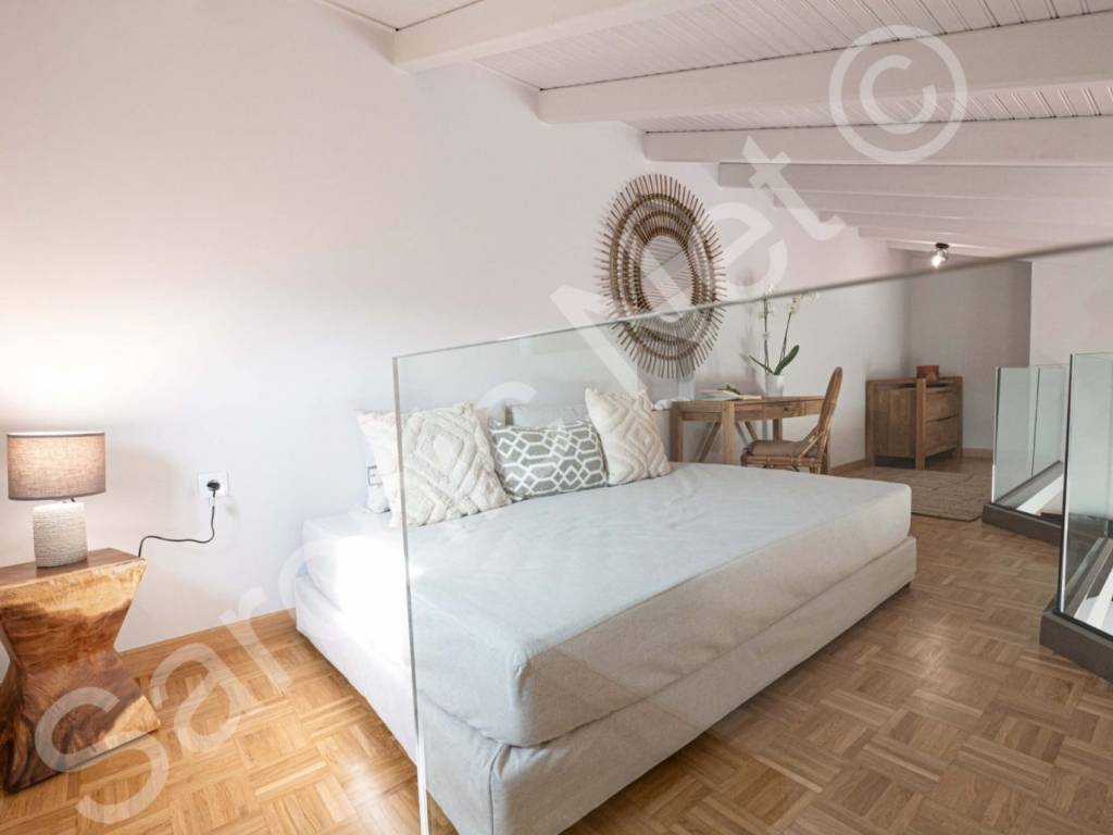 Spacious glass balconied mezzanine bedroom.