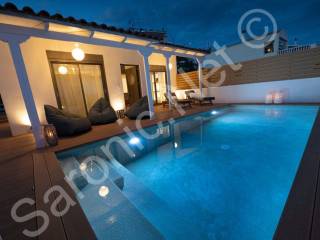 Well lit, fenced terraced area and large pool with steps.