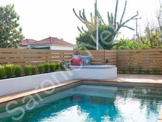 More seating and concrete planters, steps into pool.