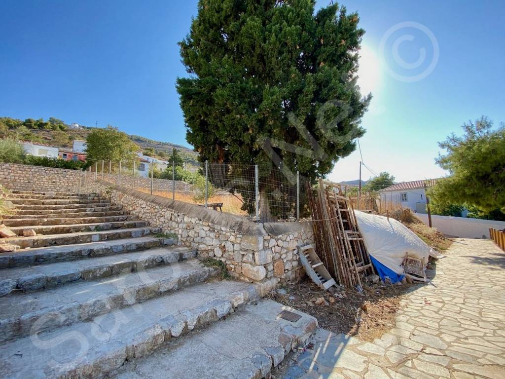 Paved street and wide stone steps at Northeast corner.