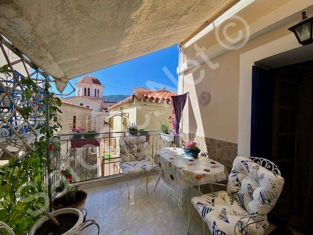 Shaded balcony terrace with pots and view of Poros street.