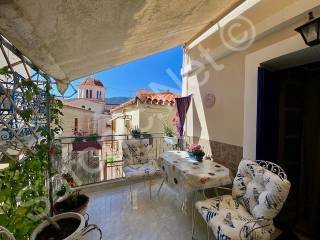 Shaded balcony terrace with pots and view of Poros street.