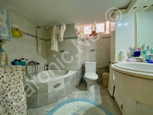 Bathroom with corner bath, sink, WC  and storage units.