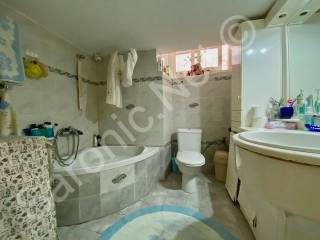 Bathroom with corner bath, sink, WC  and storage units.