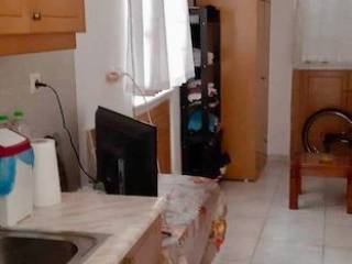Kitchenette in studio with window and storage.