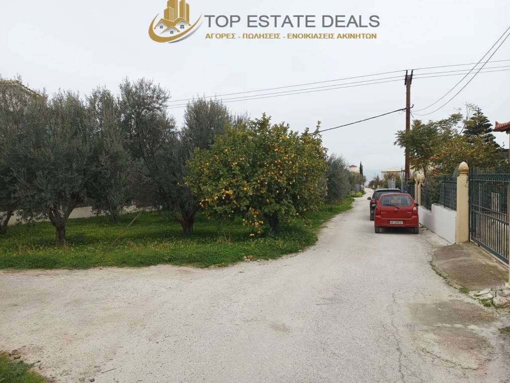 θέση οικοπέδου στην άσφαλτο δίπλα σε οικίες