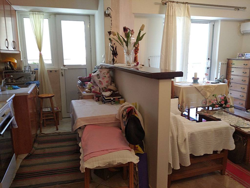 Άποψη κουζίνας με πάσο και σαλονιού δεξιά