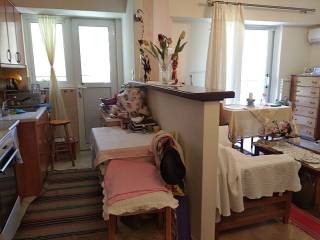 Άποψη κουζίνας με πάσο και σαλονιού δεξιά