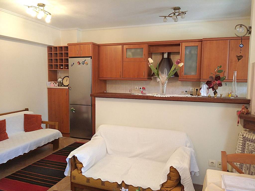 Άποψη κουζίνας με πάσο, ντουλάπια, ψυγείο, απορροφητήρα