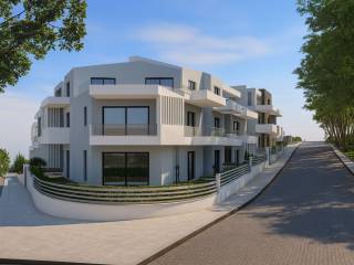 Πίσω όψη σύγχρονου κτιρίου με μπαλκόνια &amp; δέντρα.