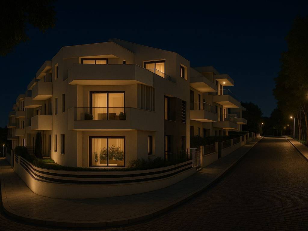 Νεόδμητο κτίριο κατοικιών φωτισμένο τη νύχτα, σε ήσυχο δρόμο