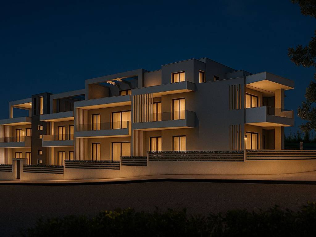Μοντέρνο κτίριο κατοικιών με ζεστό φωτισμό τη νύχτα.