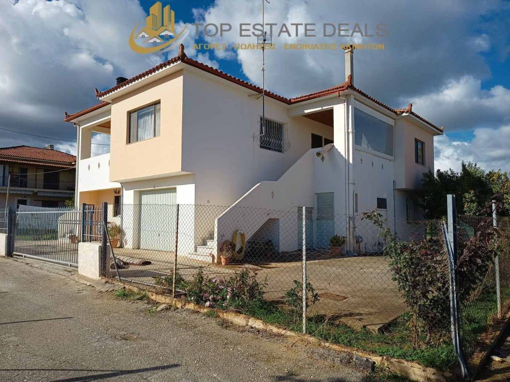 Άποψη διώροφης οικίας ,συρόμενης πόρτας γκαράζ -οικοπέδου