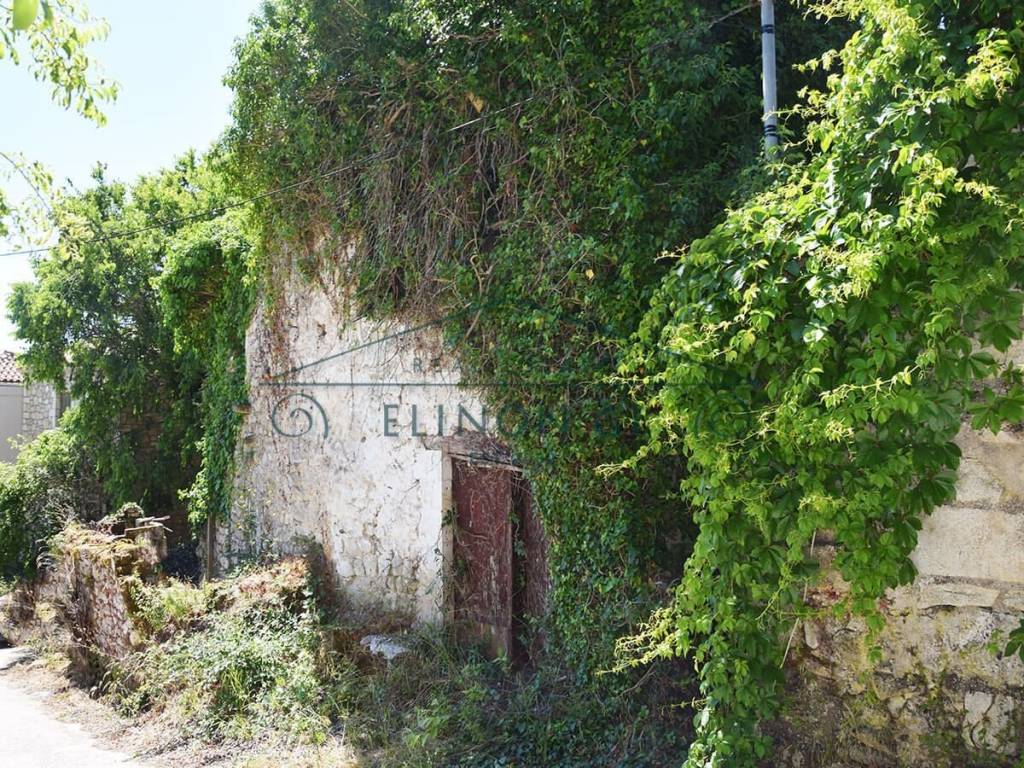 Το παλιό πέτρινο κτήριο από τον δρόμο