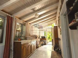 CLOSED VERANDA LEADING TO THE BACK GARDEN