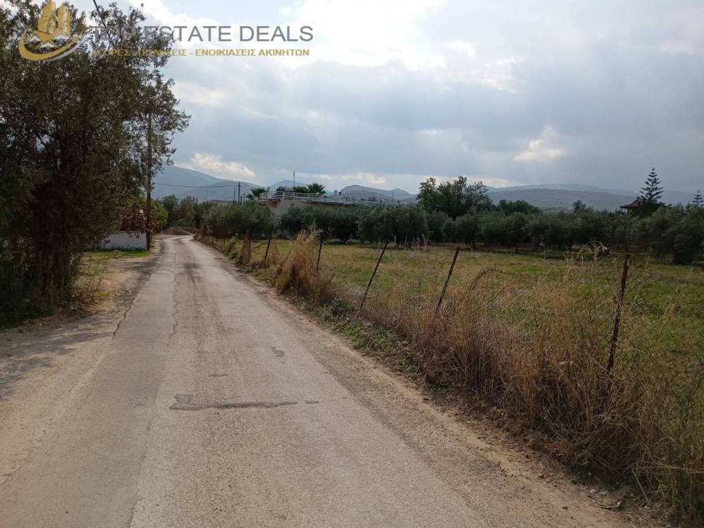 περιφραγμένο οικόπεδο στα δεξιά της κοινοτικής οδού