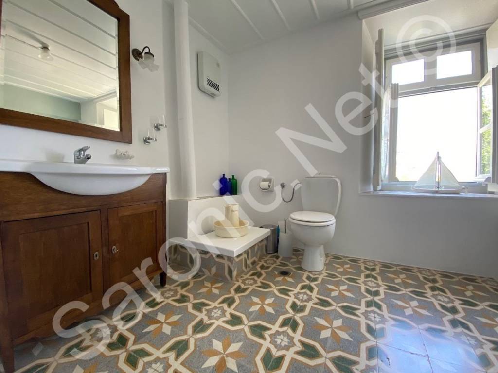 Bathroom featuring cisterna well head next to toilet