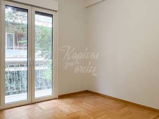 Φωτεινό υπνοδωμάτιο με παρκέ δάπεδο και μπαλκονόπορτα.