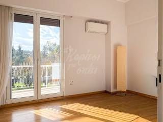 Φωτεινό δωμάτιο με παρκέ, κλιματισμό και έξοδο σε μπαλκόνι.