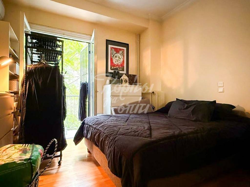 Υπνοδωμάτιο με παρκέ, φυσικό φωτισμό και έξοδο σε μπαλκόνι.