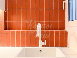 Νεροχύτης με μοντέρνα μπαταρία και κεραμικά πλακάκια τοίχου.