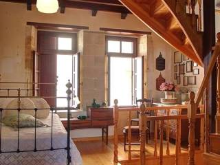 υπνοδωμάτιο με πέτρινους τοίχους και ξύλινη οροφή