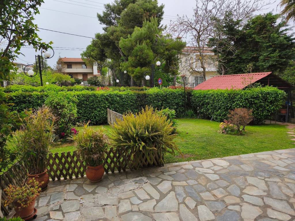 Ανάσα κήπου με γκαζόν , λουλούδια και οπωροφόρα