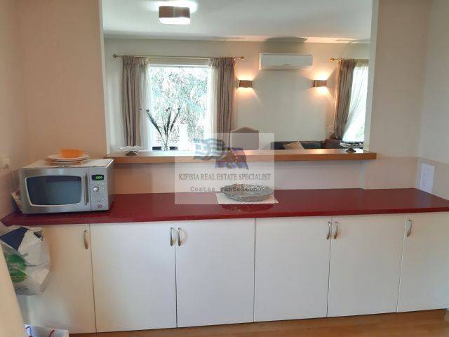 CLOSED KITCHEN WITH OPEN WINDOW IN THE LIVING ROOM